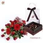 Bello ramo de rosas, gerberas y follajes, envuelto en papeles decorativo con caja de 22 bombones.