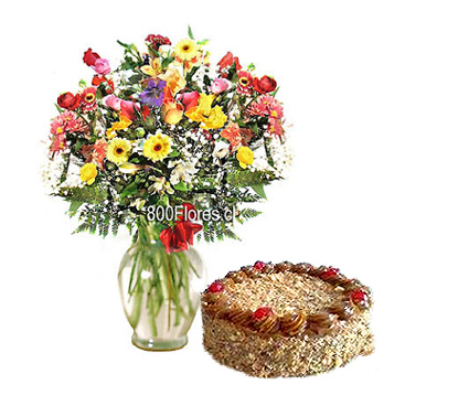Florero de vidrio con flores mixtas primaverales y torta milhojas