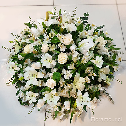 Arreglo de flores para funerales confeccionado con distintos tipo de flores blancas, apropiado par ser ubicado sobre la urna.  