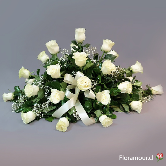 Arreglo floral con forma de cojín ovalado confeccionado de rosas y gypsophila´de color blanco y follajes, también llamado cubre urnas. por ser un arreglo floral apropiado para ser puesto sobre el ataud.